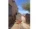 Side yard featuring brick-wall fencing, potted plants, desert landscaping, and pedestrian access at 20042 W Colter St, Litchfield Park, AZ 85340