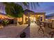 Evening shot of a backyard with a covered patio and landscaped area, offering a relaxing outdoor space at 20555 N 261St Ave, Buckeye, AZ 85396