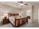 Inviting bedroom with a wood-framed bed, ceiling fan, and ensuite bathroom access at 20555 N 261St Ave, Buckeye, AZ 85396