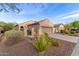 Southwest-style home featuring desert landscaping, an arched gate, and a two-car garage at 20555 N 261St Ave, Buckeye, AZ 85396