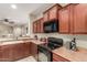 Kitchen with wood cabinets, modern appliances, and a view into the adjoining living space at 20555 N 261St Ave, Buckeye, AZ 85396