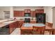 A well-lit kitchen featuring dark wood cabinetry, modern black appliances and a cozy breakfast table at 20555 N 261St Ave, Buckeye, AZ 85396