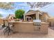 An outdoor kitchen and patio area, bathed in sunlight, perfect for relaxing and entertaining guests at 20555 N 261St Ave, Buckeye, AZ 85396