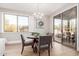 Cozy dining area with a round table, elegant chandelier, and sliding glass door to patio at 20801 N 90Th Pl # 169, Scottsdale, AZ 85255