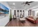 Spacious living room with large TV, great furniture, hardwood floors, and a ceiling fan at 20801 N 90Th Pl # 169, Scottsdale, AZ 85255