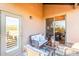 Inviting covered patio with wicker seating, glass table, and serene outdoor views through sliding glass doors at 20801 N 90Th Pl # 169, Scottsdale, AZ 85255