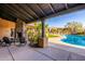 Covered patio with a stone fireplace, seating, and a view of the community pool at 20801 N 90Th Pl # 169, Scottsdale, AZ 85255