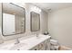 Well-lit bathroom with double sinks, framed mirrors, and a toilet in a neutral color scheme at 2118 W Hunter Ct # 136, Phoenix, AZ 85085