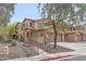 View of the three-story townhome with a tile roof, garage, and desert landscaping at 2118 W Hunter Ct # 136, Phoenix, AZ 85085