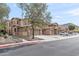 View of the three-story townhome with a tile roof, three garages, and desert landscaping at 2118 W Hunter Ct # 136, Phoenix, AZ 85085