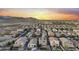 High-angle aerial shot displays planned neighborhood with pools, various roof colors, and nearby mountains at 21407 W Hubbell St, Buckeye, AZ 85396