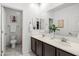 Bright bathroom featuring a double vanity with dark wood cabinets and a separate toilet room at 21407 W Hubbell St, Buckeye, AZ 85396