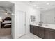 Main bathroom with double sinks, a large mirror, and a glimpse into the adjacent bedroom, creating a spa-like feel at 21407 W Hubbell St, Buckeye, AZ 85396