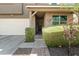 Inviting front entrance with a covered porch, manicured bushes, and a view of the garage and driveway at 21407 W Hubbell St, Buckeye, AZ 85396