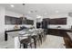 Modern kitchen with granite counters, dark cabinets, and an island with bar stool seating, perfect for casual dining at 21407 W Hubbell St, Buckeye, AZ 85396