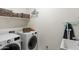 Well-equipped laundry room with modern washer and dryer, shelving for storage, and ample counter space at 21407 W Hubbell St, Buckeye, AZ 85396