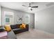 Comfortable living room with a gray sectional sofa, bright yellow pillows, and natural light from two windows at 21407 W Hubbell St, Buckeye, AZ 85396