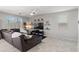 Comfortable living room features a large sectional sofa, tile flooring, and natural light from the windows at 21407 W Hubbell St, Buckeye, AZ 85396