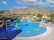 Resort-style community pool with mountain views, shade umbrellas, and comfortable lounge chairs at 21407 W Hubbell St, Buckeye, AZ 85396