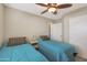 Neutral bedroom with two beds, ceiling fan, and side table with lamp at 2181 E 27Th Ave, Apache Junction, AZ 85119