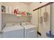 Laundry room with washer, dryer, shelving, and cleaning supplies at 2181 E 27Th Ave, Apache Junction, AZ 85119