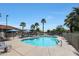 Resort-style swimming pool with palm trees, lounge chairs, and umbrellas for relaxing by the water at 2181 E 27Th Ave, Apache Junction, AZ 85119