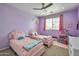Adorable bedroom with pink beds, purple walls, and cute decor at 2210 W Goldmine Mountain Dr, Queen Creek, AZ 85144