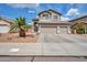 Inviting two-story home showcasing a manicured lawn, three-car garage, and classic architectural details at 2210 W Goldmine Mountain Dr, Queen Creek, AZ 85144
