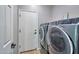 This spacious laundry room features modern machines and tile floors at 2210 W Goldmine Mountain Dr, Queen Creek, AZ 85144