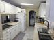 Bright kitchen features white cabinets, updated appliances, and a view of the laundry area at 2400 E Baseline Ave # 153, Apache Junction, AZ 85119