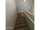Carpeted staircase with neutral walls and white railing offers a safe and stylish transition between floors at 2402 E 5Th St # 1428, Tempe, AZ 85288