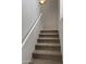 Carpeted staircase with white handrail provides access to upper levels at 2402 E 5Th St # 1428, Tempe, AZ 85288