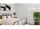 Comfortable bedroom featuring a metal bed frame, neutral colors, side tables with lamps, and a potted plant at 25207 N 183Rd Dr, Wittmann, AZ 85361