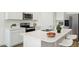Bright kitchen with stainless steel appliances, white cabinets, a double sink, and an island with bar seating at 25207 N 183Rd Dr, Wittmann, AZ 85361
