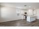 Kitchen with stainless steel appliances and white cabinetry is open to the living area at 25207 N 183Rd Dr, Wittmann, AZ 85361