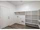 Bright laundry room features built-in shelving, washer/dryer hookups and a door leading outside at 25207 N 183Rd Dr, Wittmann, AZ 85361