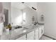 A bright bathroom features dual sinks, a marble countertop, modern lighting, and neutral decor at 26743 N 65Th Dr, Phoenix, AZ 85083