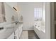 A bright bathroom features dual sinks, a marble countertop, modern lighting, and a soaking tub at 26743 N 65Th Dr, Phoenix, AZ 85083