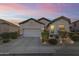 Charming home exterior featuring a two-car garage, desert landscaping and warm lighting at 26743 N 65Th Dr, Phoenix, AZ 85083