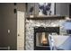 Living room with a stone fireplace, wooden mantel, and decorative art, creating a warm and inviting ambiance at 26743 N 65Th Dr, Phoenix, AZ 85083