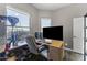 This home office features a large desk area, natural light, dark wood floors, and a neutral color scheme at 26743 N 65Th Dr, Phoenix, AZ 85083