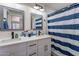 Stylish bathroom with double sinks, modern fixtures, and a blue striped shower curtain at 2714 E Valencia Dr, Phoenix, AZ 85042