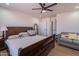 Spacious bedroom with ceiling fan, wood floors, and a cozy seating area at 2714 E Valencia Dr, Phoenix, AZ 85042