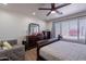Bright bedroom featuring a ceiling fan, wood floors, and a large window for lots of natural light at 2714 E Valencia Dr, Phoenix, AZ 85042