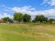 Expansive community park with green grass, mature trees, and a playground under a blue sky with white clouds at 2714 E Valencia Dr, Phoenix, AZ 85042
