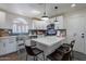 Well-lit kitchen featuring white cabinets and a center island with bar stool seating at 2714 E Valencia Dr, Phoenix, AZ 85042
