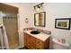 Well-lit bathroom featuring a shower, vanity with sink, decorative mirror, and stylish black and white accents at 3015 E Sells Dr, Phoenix, AZ 85016