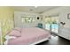 Bright bedroom with a white metal bed frame, pink bedding, and a glass door leading to the pool area at 3015 E Sells Dr, Phoenix, AZ 85016