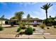 Charming home with desert landscaping, stepping stone walkway, and a well-manicured lawn and blue skies at 3015 E Sells Dr, Phoenix, AZ 85016
