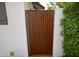 Rustic metal gate set within a white brick wall, surrounded by lush greenery and offering privacy at 3015 E Sells Dr, Phoenix, AZ 85016